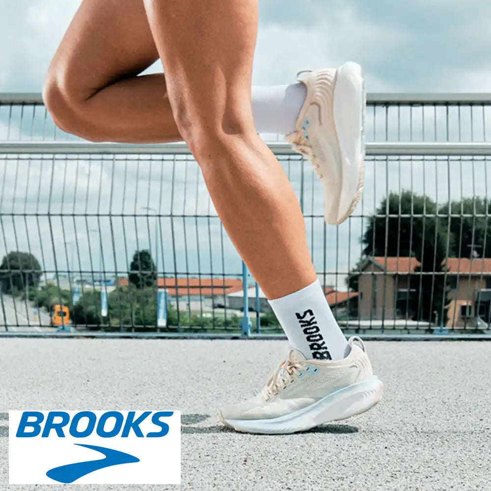 Person running outdoors wearing Brooks shoes and socks with a blurred background