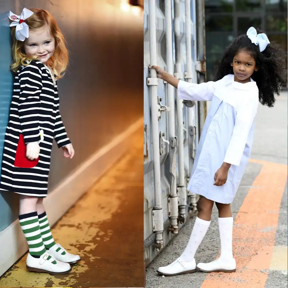 Two children in different outfits standing next to each other.