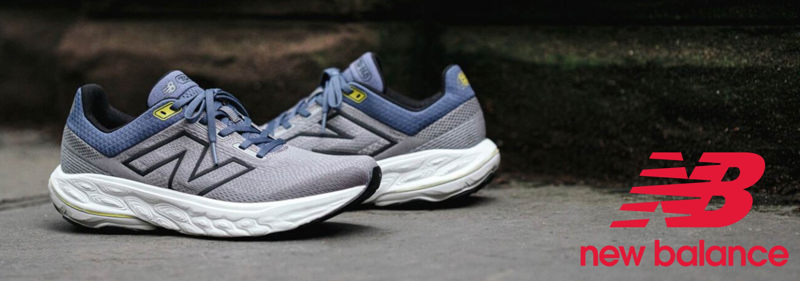 Gray and blue running shoes with New Balance logo on a dark background